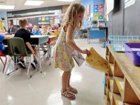 A first grade student prepares her folder in the cubbies inside jer classroom at the Casimir Pulaski school, as students across New Bedford return to school.  [ PETER PEREIRA/THE STANDARD-TIMES/SCMG ]